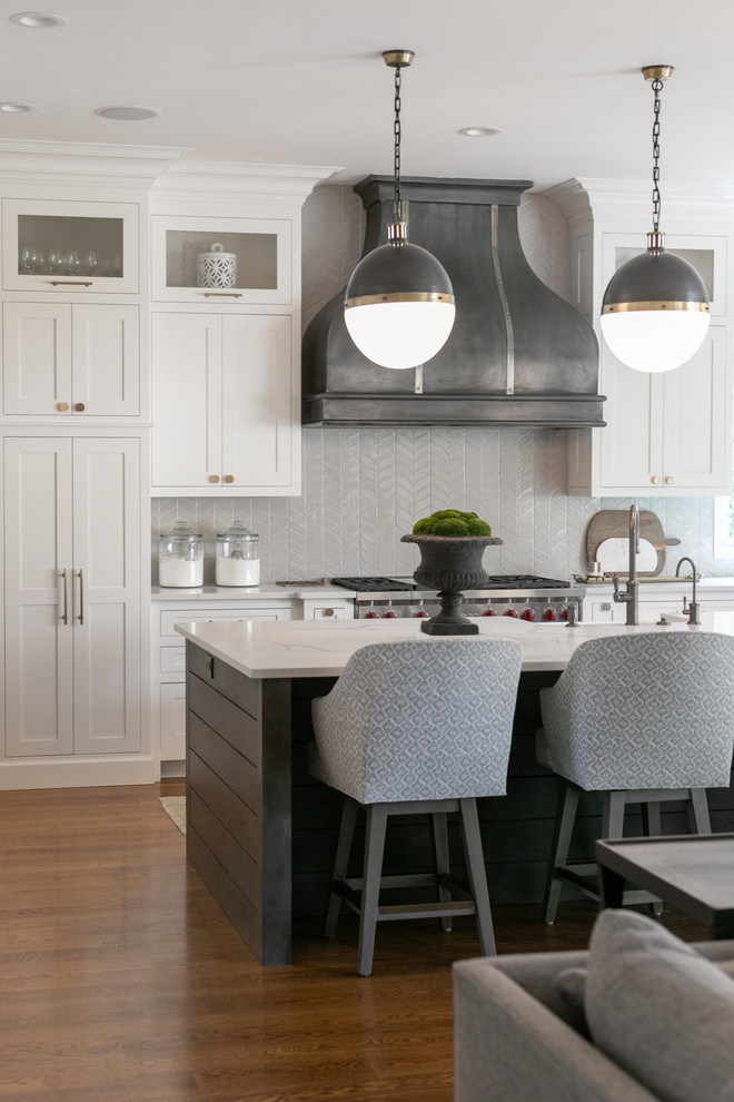 Foto på ett vintage vit kök med öppen planlösning, med skåp i shakerstil, integrerade vitvaror, mellanmörkt trägolv, en köksö, brunt golv, vita skåp, bänkskiva i kvarts och grått stänkskydd