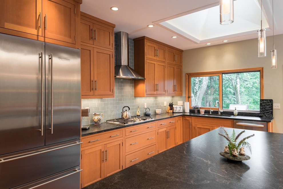 Inspiration for a large contemporary l-shaped light wood floor open concept kitchen remodel in New York with an undermount sink, shaker cabinets, light wood cabinets, granite countertops, gray backsplash, glass tile backsplash, stainless steel appliances and an island