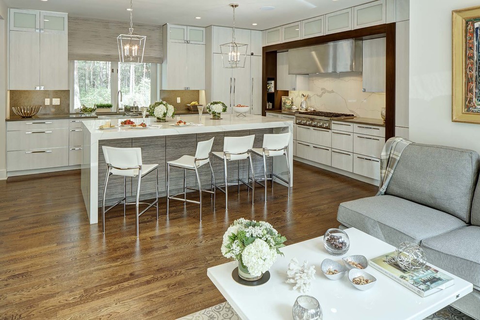Example of a mid-sized trendy l-shaped medium tone wood floor eat-in kitchen design in New York with a farmhouse sink, glass-front cabinets, gray cabinets, quartz countertops, white backsplash, stone slab backsplash, stainless steel appliances and an island