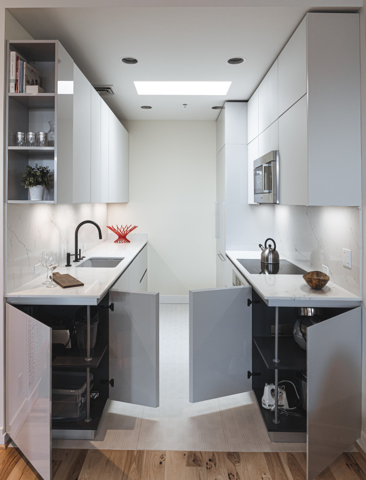 This is an example of a small modern galley kitchen/diner in Portland with a submerged sink, flat-panel cabinets, grey cabinets, engineered stone countertops, white splashback, engineered quartz splashback, integrated appliances, ceramic flooring, no island, white floors and white worktops.