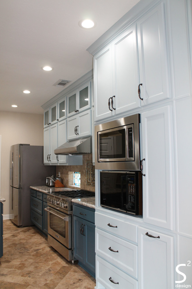 Idéer för att renovera ett mellanstort eklektiskt flerfärgad flerfärgat kök och matrum, med en undermonterad diskho, luckor med infälld panel, blå skåp, granitbänkskiva, beige stänkskydd, stänkskydd i travertin, rostfria vitvaror, vinylgolv, en köksö och beiget golv