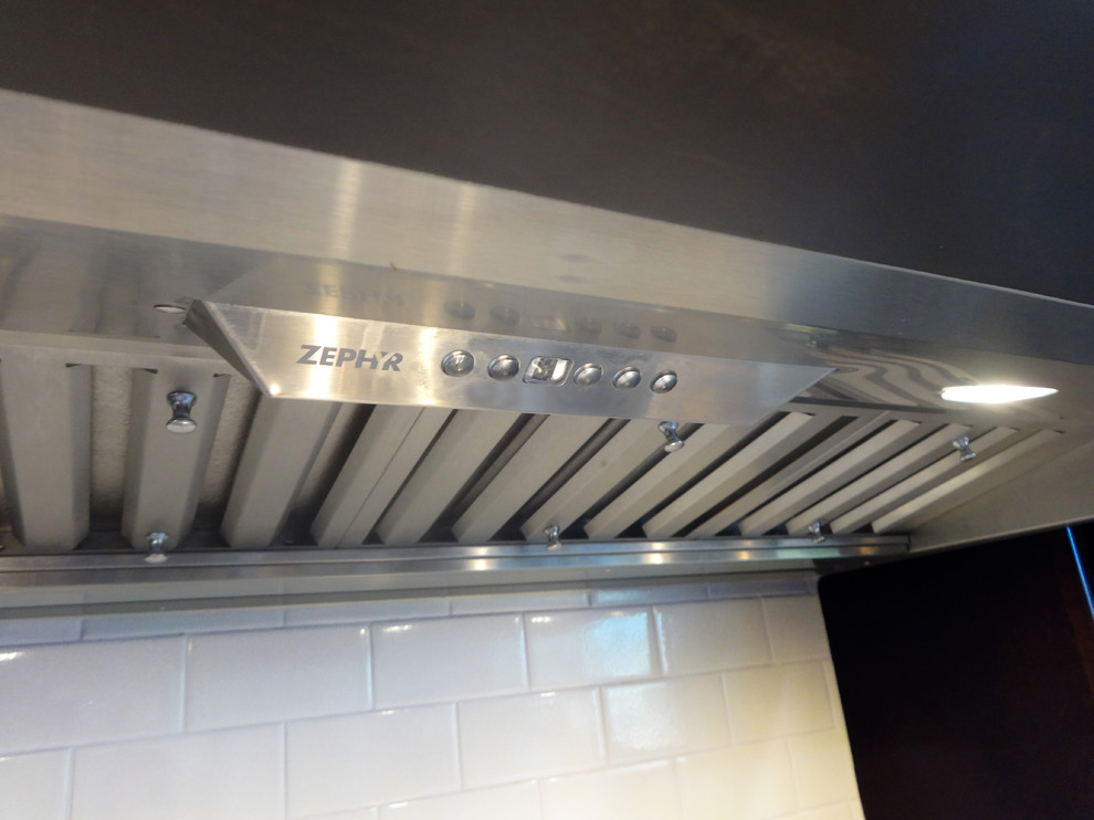 Cette photo montre une cuisine moderne avec une crédence en carrelage métro et un électroménager en acier inoxydable.