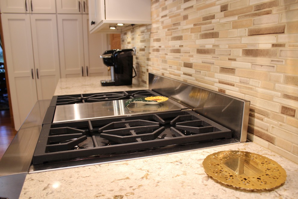 Example of an arts and crafts u-shaped medium tone wood floor kitchen design in Portland with a single-bowl sink, shaker cabinets, quartz countertops, multicolored backsplash, mosaic tile backsplash and paneled appliances