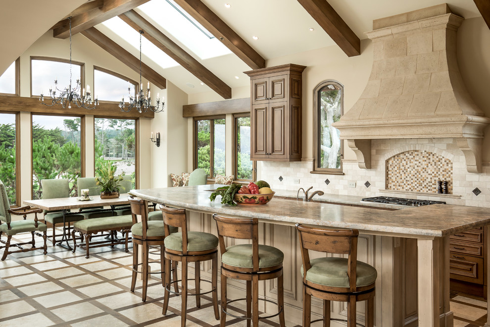 Large mediterranean single-wall open plan kitchen in San Francisco with a belfast sink, brown cabinets, engineered stone countertops, beige splashback, ceramic splashback, stainless steel appliances, ceramic flooring, an island, beige floors, beige worktops and recessed-panel cabinets.