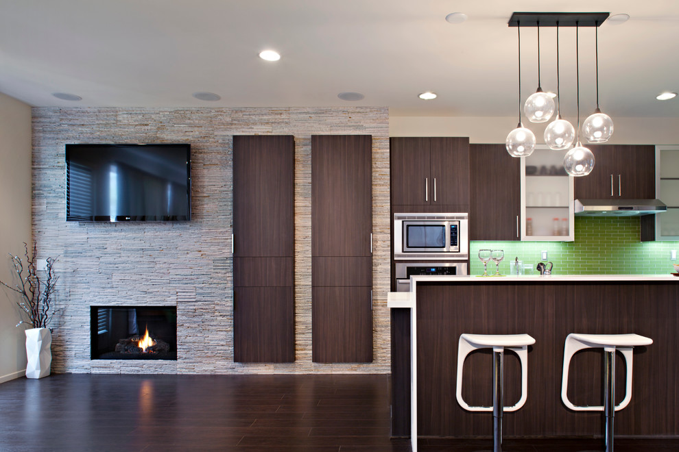 Example of a mid-sized trendy galley dark wood floor kitchen design in Atlanta with flat-panel cabinets, dark wood cabinets, quartz countertops, an island, green backsplash, glass tile backsplash and stainless steel appliances