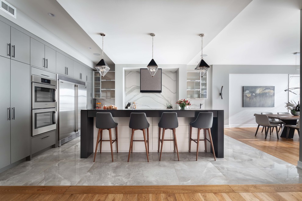 Example of a large trendy ceramic tile and gray floor open concept kitchen design in Ottawa with flat-panel cabinets, gray cabinets, quartz countertops, white backsplash, stone slab backsplash, stainless steel appliances, an island and white countertops