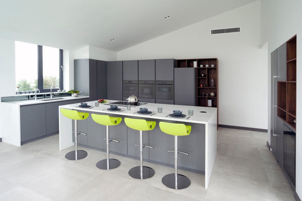 Large contemporary l-shaped open plan kitchen in Essex with flat-panel cabinets, grey cabinets, quartz worktops, mirror splashback, coloured appliances, porcelain flooring, an island, grey floors and white worktops.