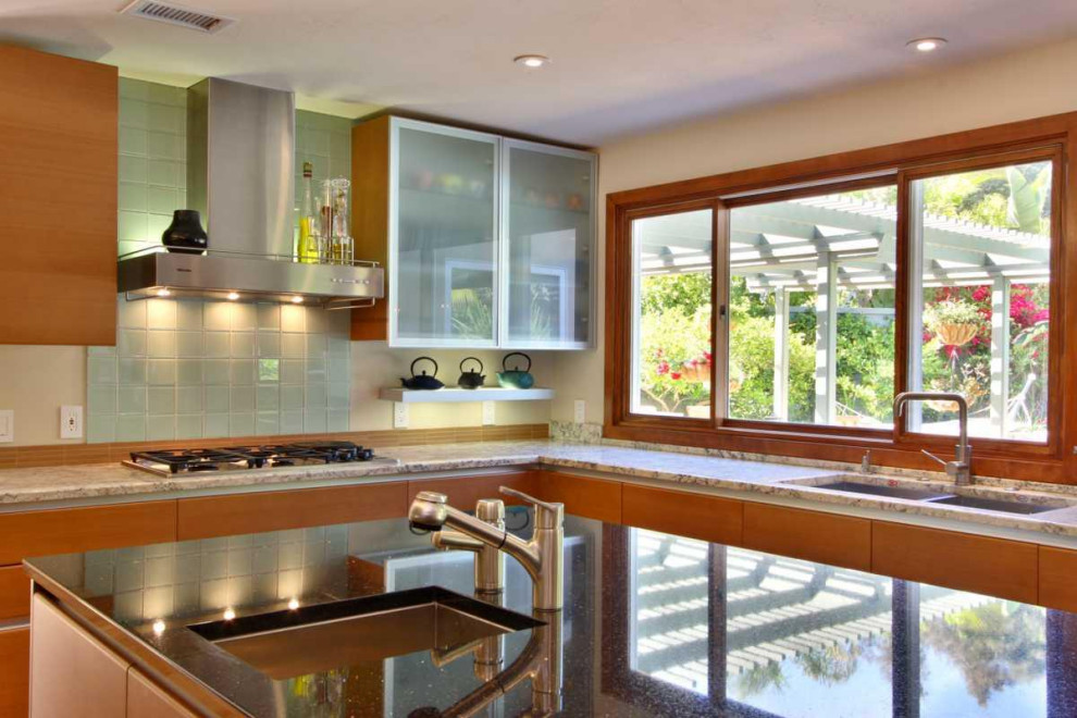 Idéer för att renovera ett stort 50 tals grå grått kök, med en undermonterad diskho, släta luckor, skåp i mellenmörkt trä, bänkskiva i glas, grönt stänkskydd, stänkskydd i glaskakel, rostfria vitvaror, mellanmörkt trägolv, en köksö och turkost golv