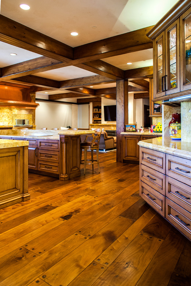 Cette image montre une très grande cuisine chalet en bois brun avec un sol en bois brun et 2 îlots.