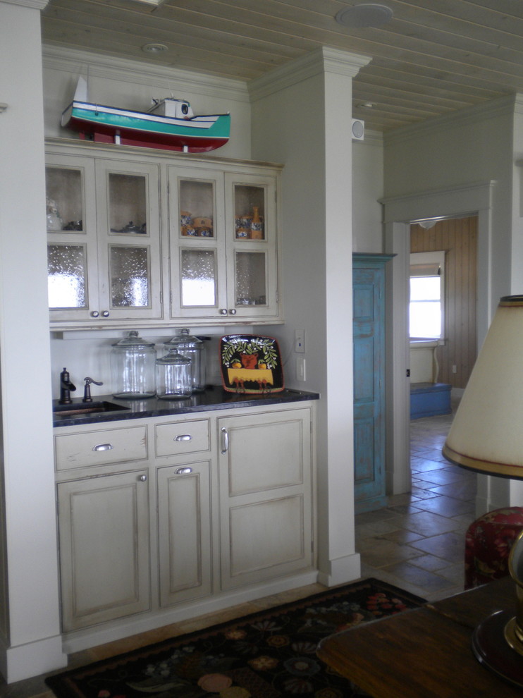 Exempel på ett mellanstort lantligt kök, med en undermonterad diskho, skåp i slitet trä, granitbänkskiva, luckor med infälld panel, vitt stänkskydd, stänkskydd i mosaik, rostfria vitvaror, skiffergolv och en köksö