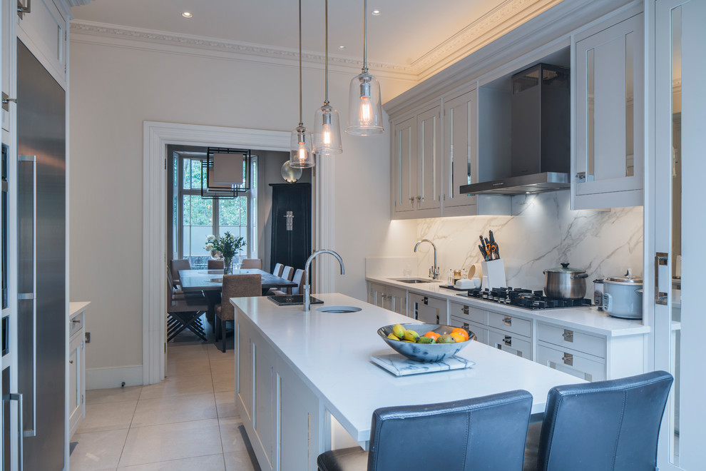Zweizeilige Moderne Küche mit Unterbauwaschbecken, Schrankfronten mit vertiefter Füllung, weißen Schränken, Rückwand aus Marmor und Kücheninsel in London