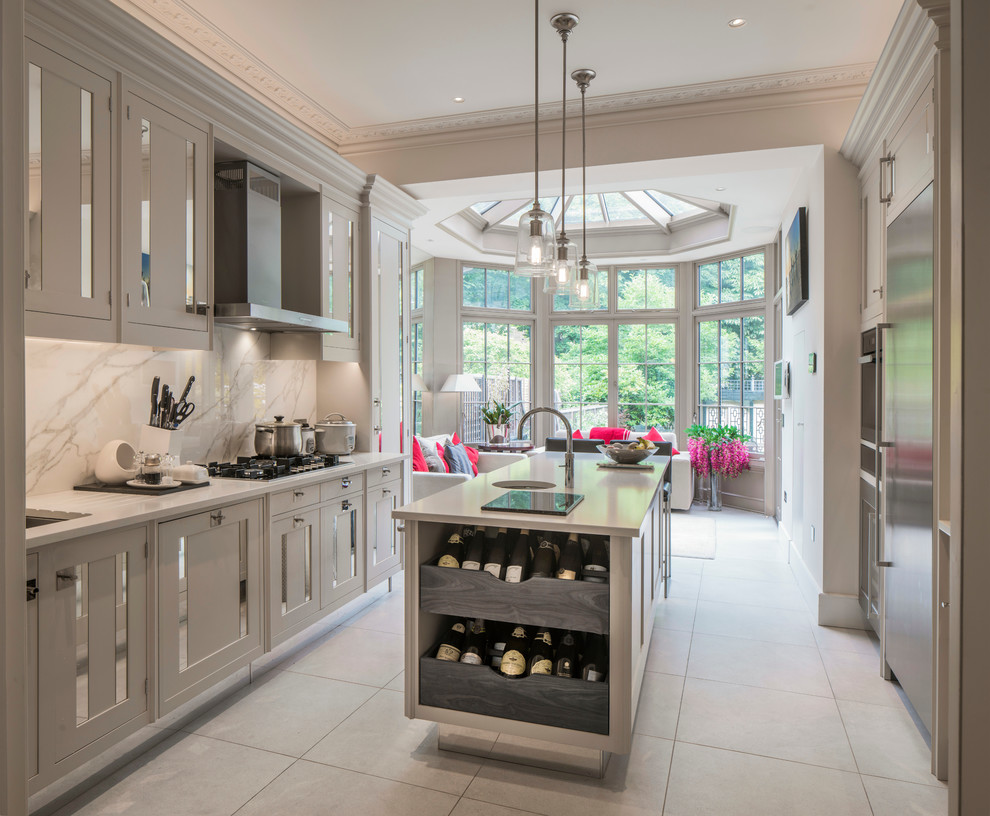 Mid-sized transitional galley gray floor eat-in kitchen photo in London with an undermount sink, recessed-panel cabinets, gray cabinets, white backsplash, marble backsplash and an island