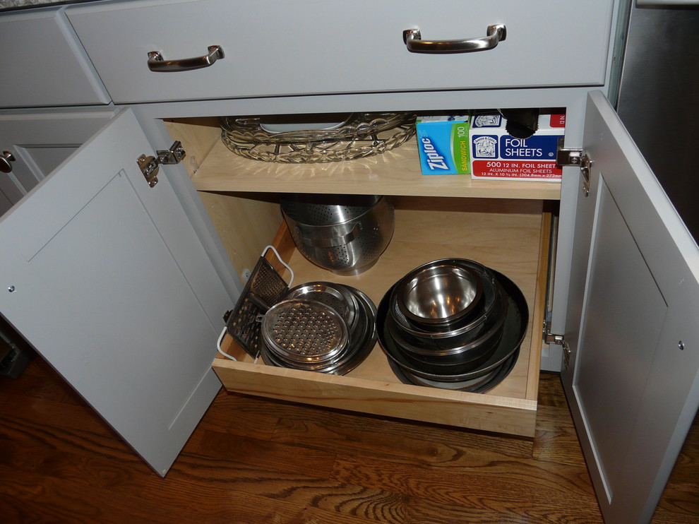 Exempel på ett mellanstort klassiskt kök, med en undermonterad diskho, luckor med infälld panel, grå skåp, bänkskiva i kvarts, stänkskydd i tunnelbanekakel, rostfria vitvaror, mellanmörkt trägolv och en köksö