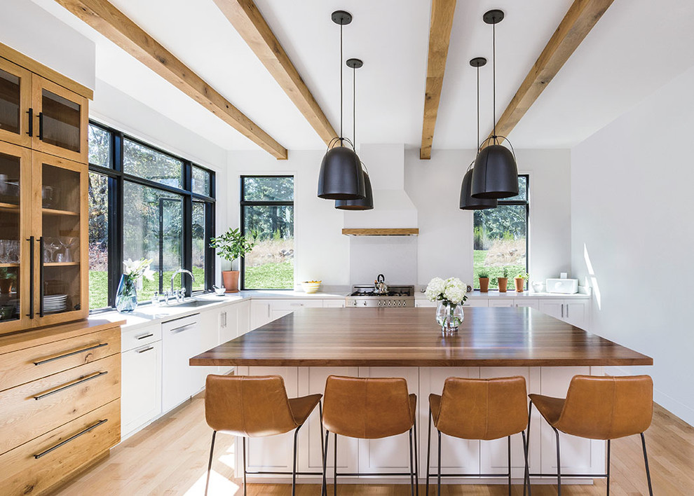 Inspiration for a transitional l-shaped light wood floor and beige floor enclosed kitchen remodel in Denver with shaker cabinets, white cabinets, wood countertops, stainless steel appliances, an island and brown countertops