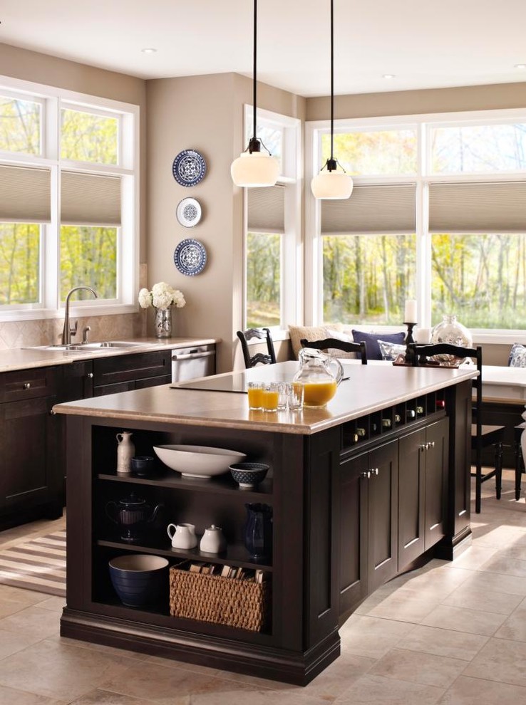 Inspiration for a mid-sized transitional u-shaped limestone floor open concept kitchen remodel in New York with a drop-in sink, flat-panel cabinets, medium tone wood cabinets, granite countertops, black backsplash, ceramic backsplash, black appliances and an island