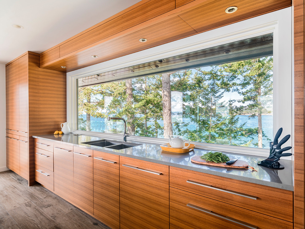 На фото: кухня в морском стиле с двойной мойкой, плоскими фасадами, фасадами цвета дерева среднего тона и паркетным полом среднего тона
