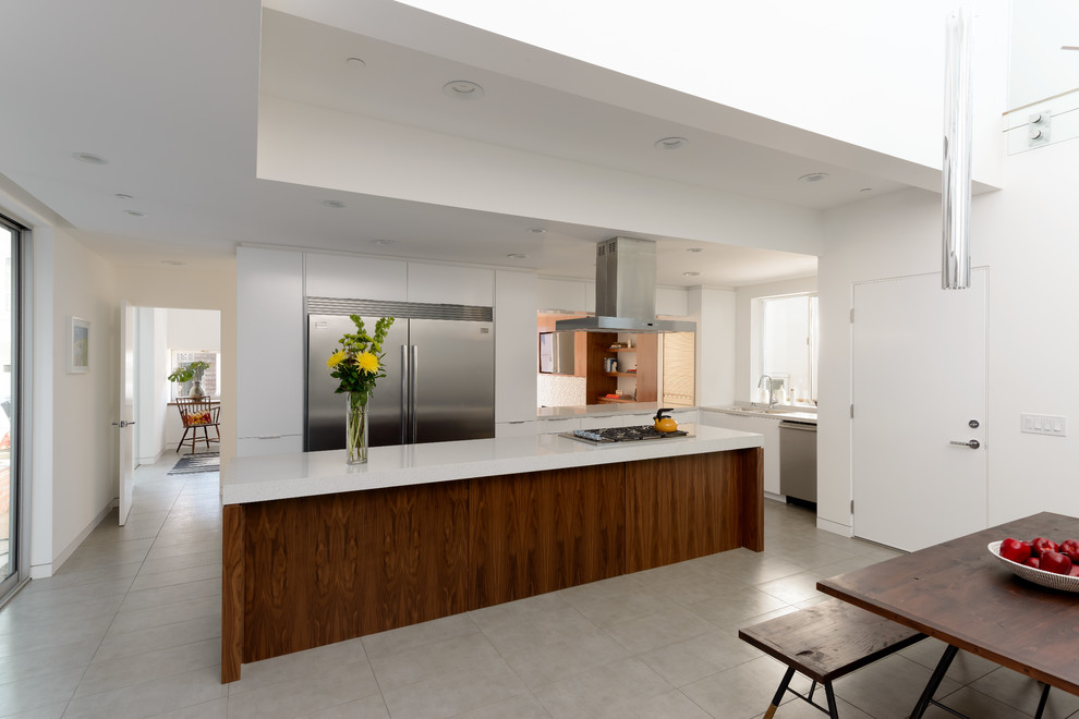 Moderne Wohnküche mit flächenbündigen Schrankfronten, weißen Schränken und Küchengeräten aus Edelstahl in Los Angeles