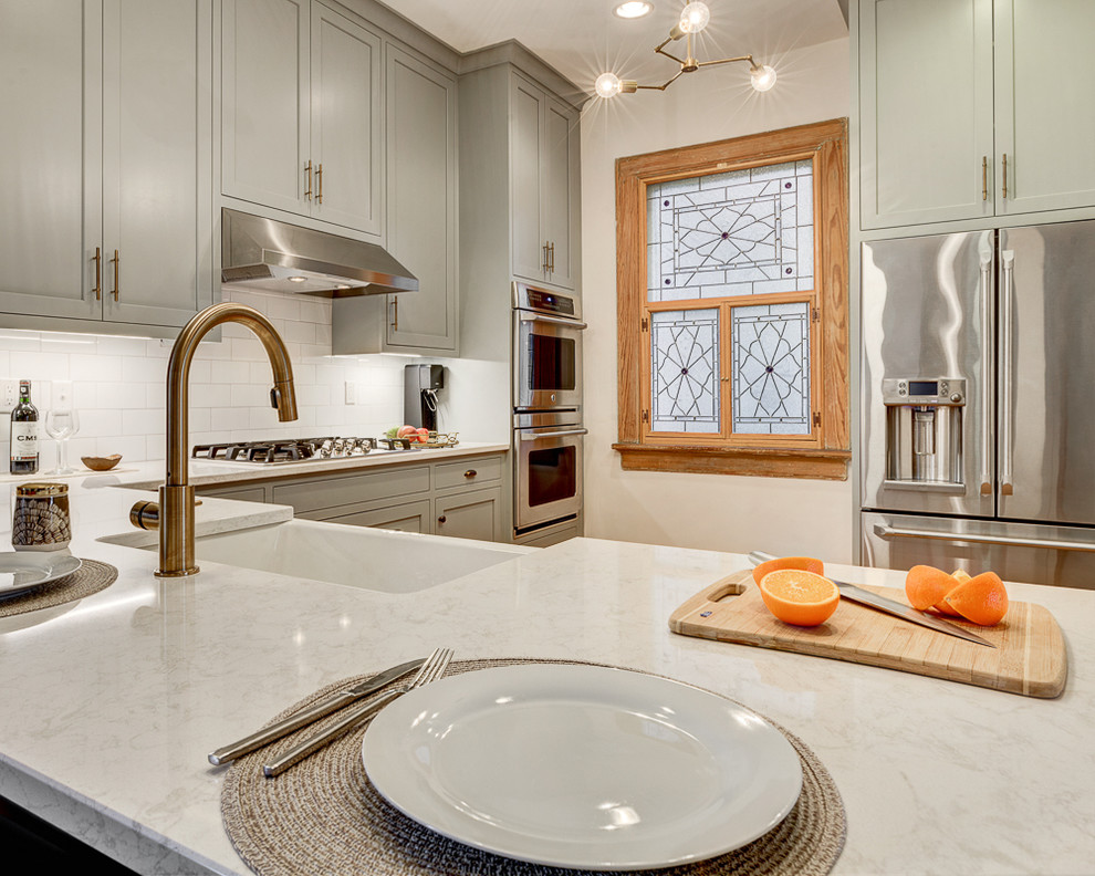 Eat-in kitchen - mid-sized modern l-shaped light wood floor eat-in kitchen idea in Los Angeles with a farmhouse sink, beaded inset cabinets, gray cabinets, quartzite countertops, white backsplash, subway tile backsplash, stainless steel appliances and a peninsula
