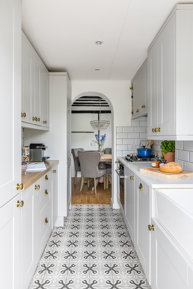 Diseño de cocina de estilo de casa de campo cerrada con armarios estilo shaker, encimera de cuarcita, salpicadero de azulejos de cerámica y suelo de baldosas de cerámica