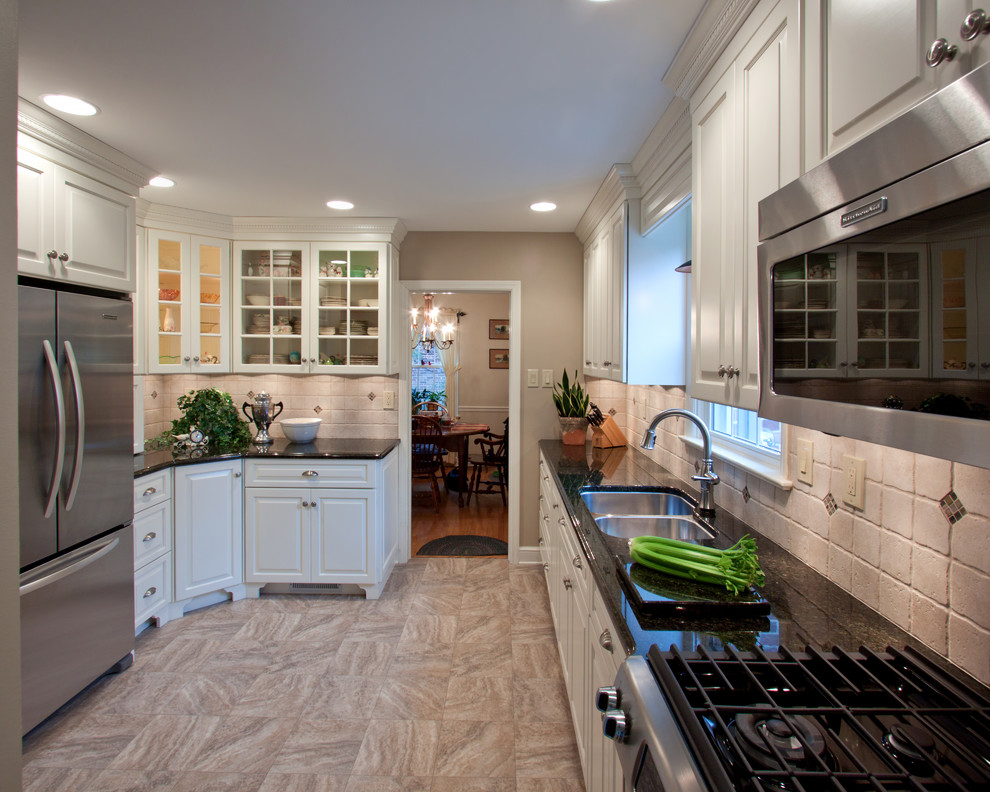 Inspiration for a small transitional u-shaped vinyl floor and multicolored floor enclosed kitchen remodel in Baltimore with a double-bowl sink, raised-panel cabinets, white cabinets, granite countertops, beige backsplash, ceramic backsplash, stainless steel appliances and no island