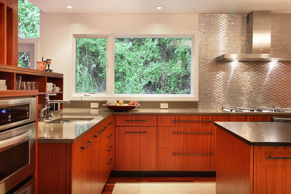 Exempel på ett modernt kök, med rostfria vitvaror, släta luckor, skåp i mellenmörkt trä, stänkskydd med metallisk yta och stänkskydd i metallkakel
