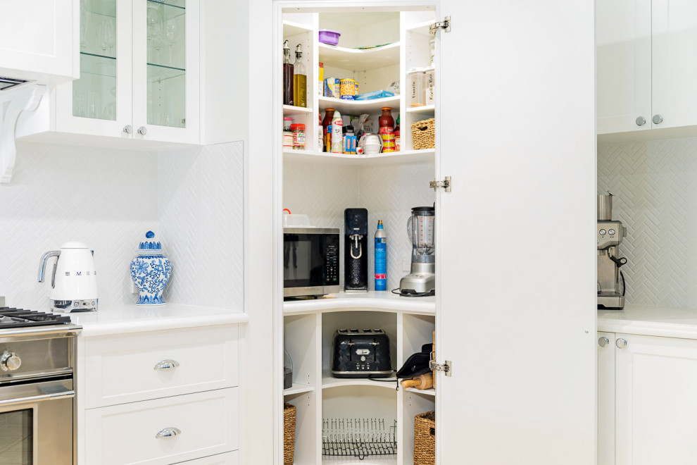 Foto på ett mellanstort vit kök, med en undermonterad diskho, skåp i shakerstil, vita skåp, bänkskiva i kvartsit, vitt stänkskydd, stänkskydd i keramik, rostfria vitvaror och en halv köksö