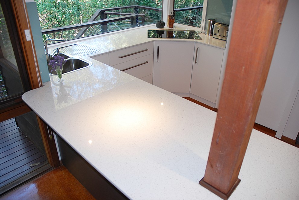 Mid-sized minimalist u-shaped cork floor kitchen pantry photo in Sydney with a drop-in sink, flat-panel cabinets, white cabinets, quartz countertops, green backsplash, stainless steel appliances and a peninsula