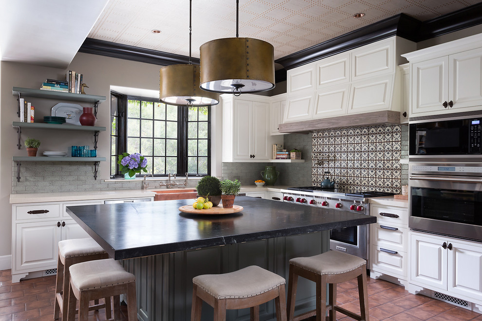 Inspiration för mellanstora medelhavsstil l-kök, med luckor med upphöjd panel, vita skåp, rostfria vitvaror, en köksö, en rustik diskho och flerfärgad stänkskydd