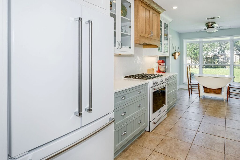 Example of a mid-sized beach style galley porcelain tile and brown floor eat-in kitchen design in Charlotte with a farmhouse sink, beaded inset cabinets, white cabinets, quartz countertops, white backsplash, subway tile backsplash, white appliances, no island and white countertops
