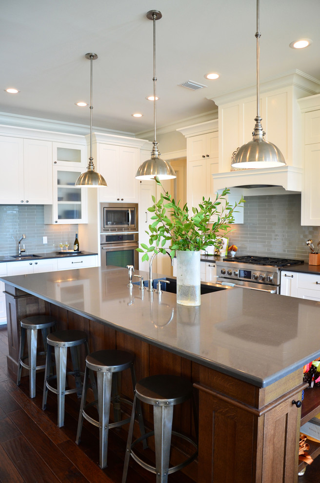 Klassische Küche mit weißen Schränken, Küchenrückwand in Grau, Rückwand aus Metrofliesen und Küchengeräten aus Edelstahl in Miami