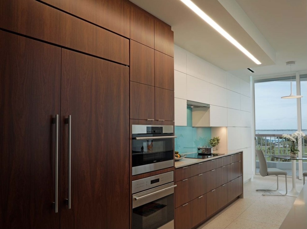 Exempel på ett mellanstort modernt kök och matrum, med en enkel diskho, släta luckor, skåp i mellenmörkt trä, bänkskiva i kvarts, glaspanel som stänkskydd, integrerade vitvaror, terrazzogolv, en köksö och vitt golv