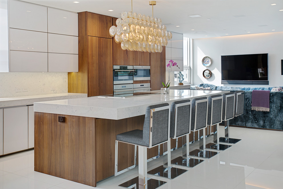 Foto di una cucina minimal con ante lisce, ante in legno scuro, paraspruzzi bianco, elettrodomestici in acciaio inossidabile, pavimento bianco e top bianco