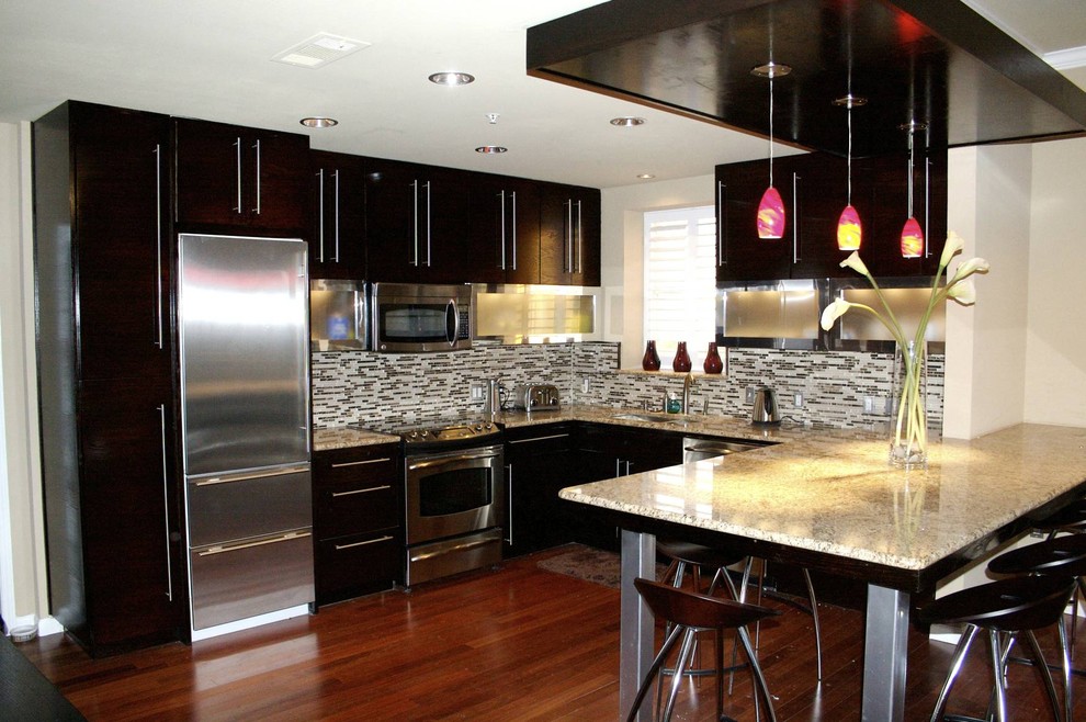 Moderne Küche in U-Form mit flächenbündigen Schrankfronten, Küchengeräten aus Edelstahl, schwarzen Schränken und bunter Rückwand in Dallas