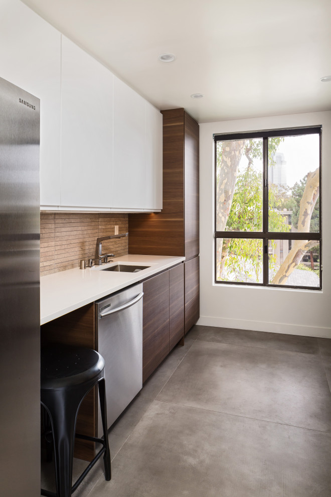 Example of a small trendy galley concrete floor and gray floor enclosed kitchen design in Los Angeles with an undermount sink, flat-panel cabinets, dark wood cabinets, quartz countertops, gray backsplash, limestone backsplash, stainless steel appliances, no island and white countertops