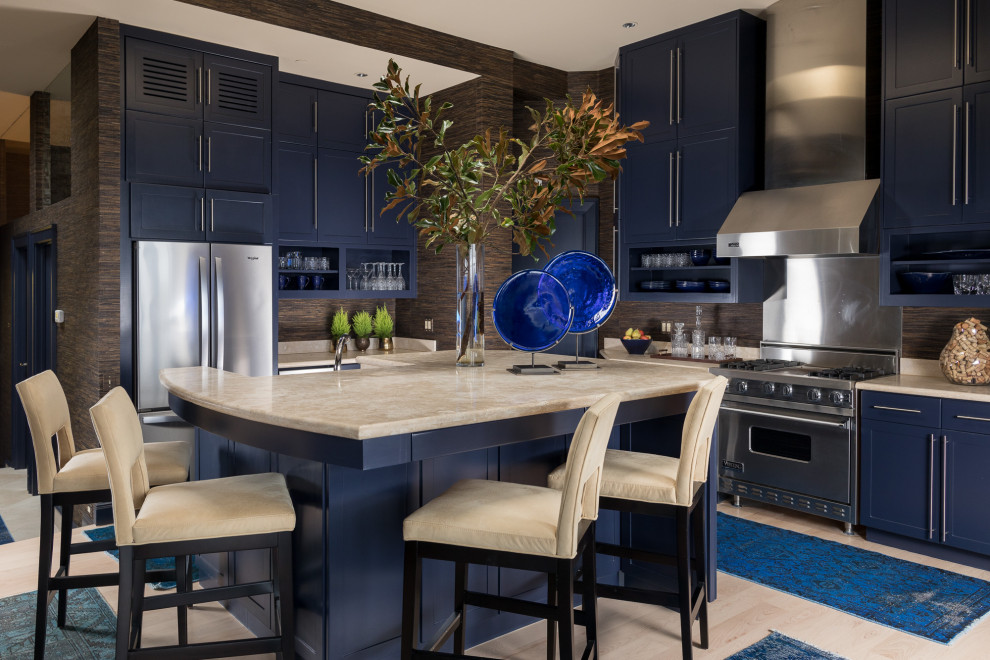 Exempel på ett modernt beige beige l-kök, med en dubbel diskho, blå skåp, marmorbänkskiva, brunt stänkskydd, rostfria vitvaror, ljust trägolv, en köksö, beiget golv och skåp i shakerstil