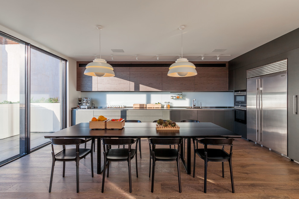 Einzeilige Moderne Wohnküche mit braunem Boden, flächenbündigen Schrankfronten, grauen Schränken, Küchengeräten aus Edelstahl und braunem Holzboden in Tel Aviv