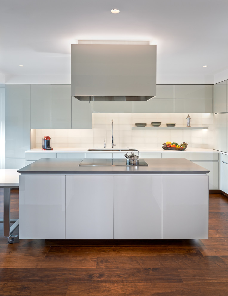 Large contemporary u-shaped kitchen/diner in DC Metro with a double-bowl sink, flat-panel cabinets, white cabinets, engineered stone countertops, integrated appliances, dark hardwood flooring and an island.