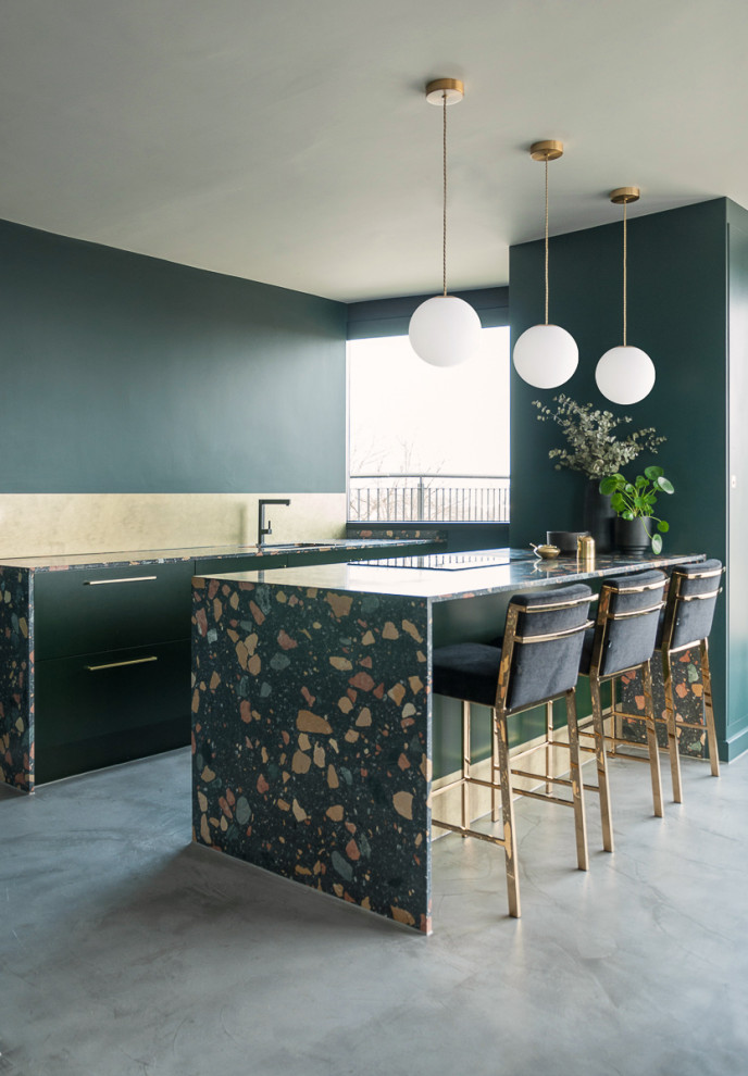 This is an example of a medium sized contemporary galley open plan kitchen in London with flat-panel cabinets, green cabinets, terrazzo worktops, metallic splashback, a breakfast bar, grey floors, multicoloured worktops, a submerged sink and integrated appliances.