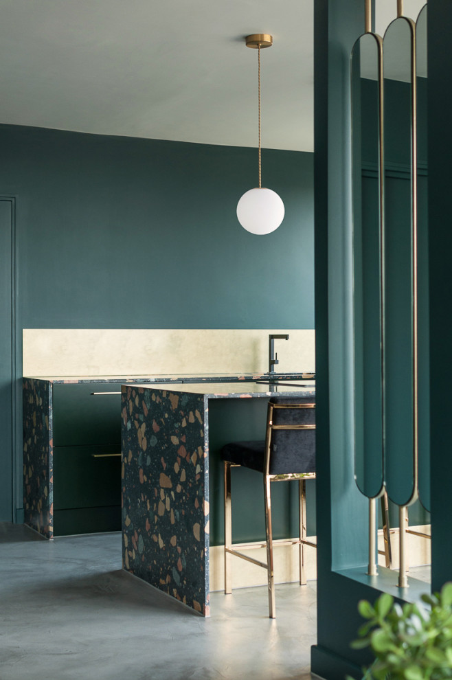 Eklektisk inredning av ett mellanstort flerfärgad flerfärgat kök, med en enkel diskho, släta luckor, gröna skåp, bänkskiva i terrazo, stänkskydd med metallisk yta, svarta vitvaror, betonggolv, en halv köksö och grått golv