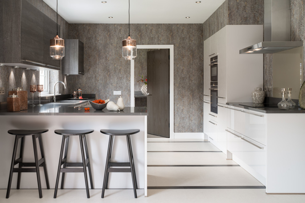Mittelgroße Moderne Küche mit weißen Schränken, Granit-Arbeitsplatte, Marmorboden, Halbinsel, flächenbündigen Schrankfronten und Küchenrückwand in Grau in London