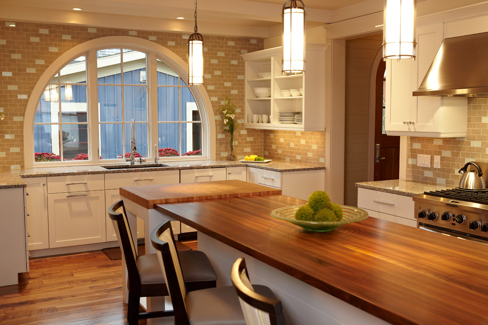 Example of a beach style kitchen design in Grand Rapids with wood countertops