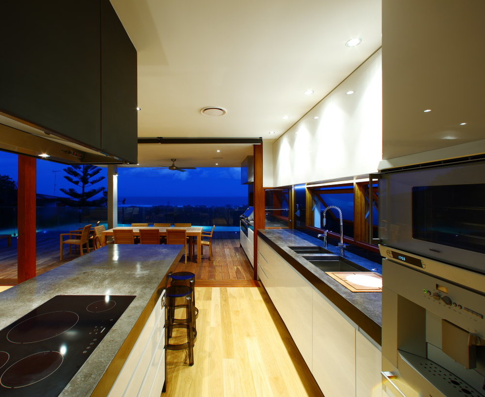 На фото: кухня в современном стиле с столешницей из бетона и техникой из нержавеющей стали с