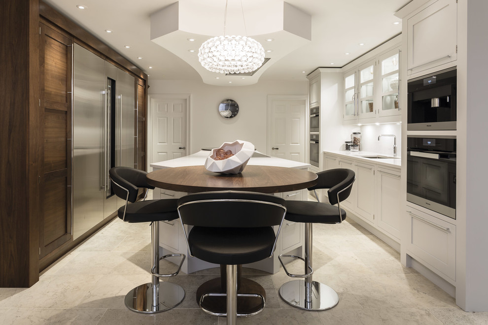 This is an example of a large modern kitchen/diner in Manchester with a submerged sink, dark wood cabinets, integrated appliances, an island and flat-panel cabinets.