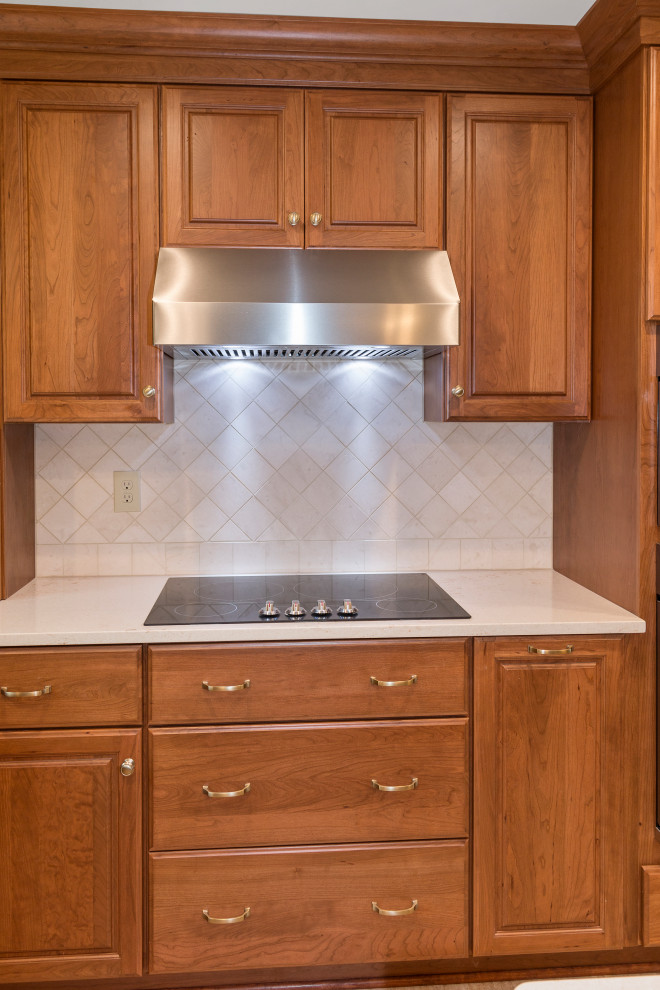 Inredning av ett klassiskt mellanstort beige beige kök, med en undermonterad diskho, luckor med upphöjd panel, bruna skåp, bänkskiva i kvarts, beige stänkskydd, stänkskydd i stenkakel, rostfria vitvaror, vinylgolv, en köksö och brunt golv