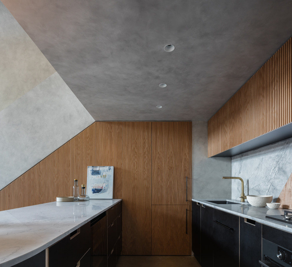 Esempio di una piccola cucina parallela minimalista chiusa con lavello sottopiano, ante nere, top in marmo, paraspruzzi grigio, paraspruzzi in marmo, elettrodomestici neri, pavimento in cemento, pavimento grigio e top grigio