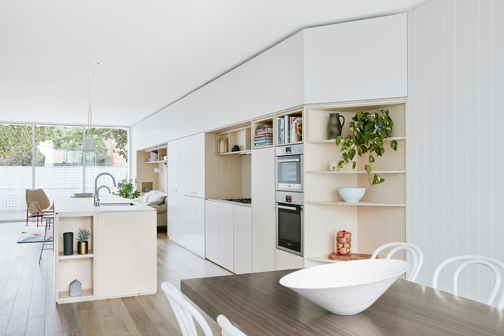 Idee per una cucina design con lavello sottopiano, ante lisce, ante in legno chiaro, pavimento in legno massello medio e pavimento marrone