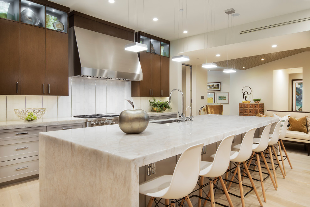 Moderne Küche mit Küchenrückwand in Weiß, Küchengeräten aus Edelstahl, hellem Holzboden, Kücheninsel, flächenbündigen Schrankfronten und dunklen Holzschränken in Orange County