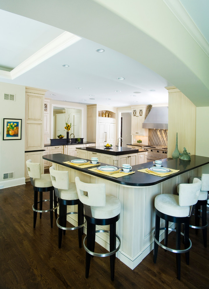 This is an example of a large classic u-shaped open plan kitchen in Chicago with a submerged sink, raised-panel cabinets, white cabinets, granite worktops, black splashback, stone slab splashback, integrated appliances, dark hardwood flooring and multiple islands.