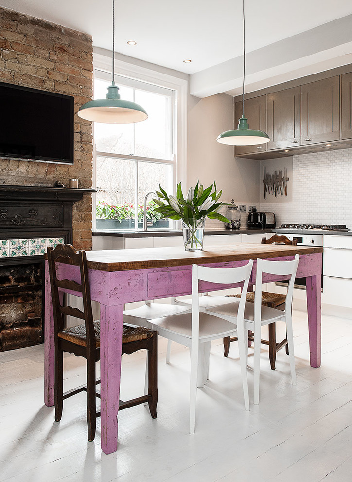 Inspiration for a mid-sized country l-shaped painted wood floor enclosed kitchen remodel in London with an undermount sink, shaker cabinets, granite countertops, white backsplash, mosaic tile backsplash and stainless steel appliances