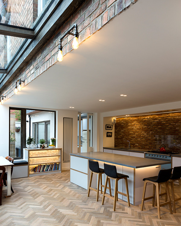 Offene, Einzeilige, Große Moderne Küche mit Rückwand aus Backstein, braunem Holzboden und Kücheninsel in Dublin